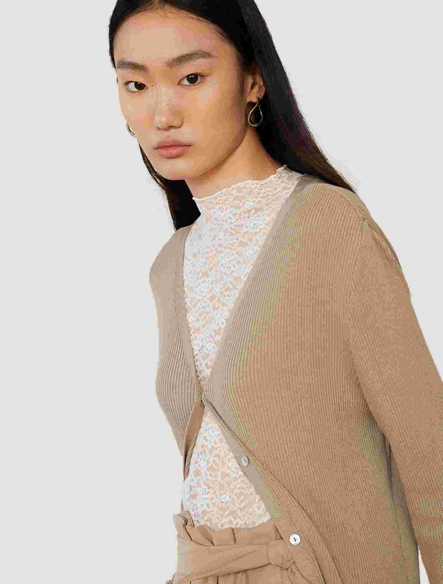 White sheer lace bell sleeve top layered under knitwear